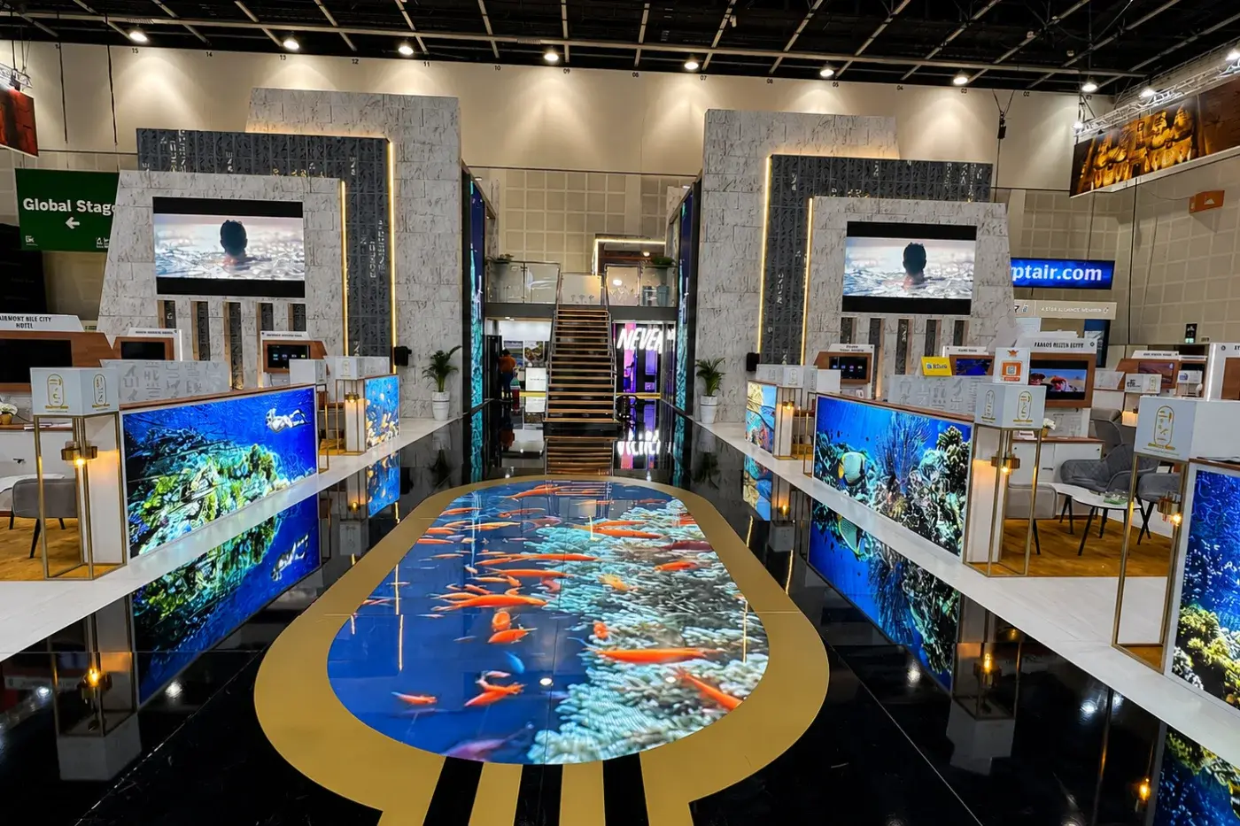 Large island stand with a printed floor graphic and several demo zones