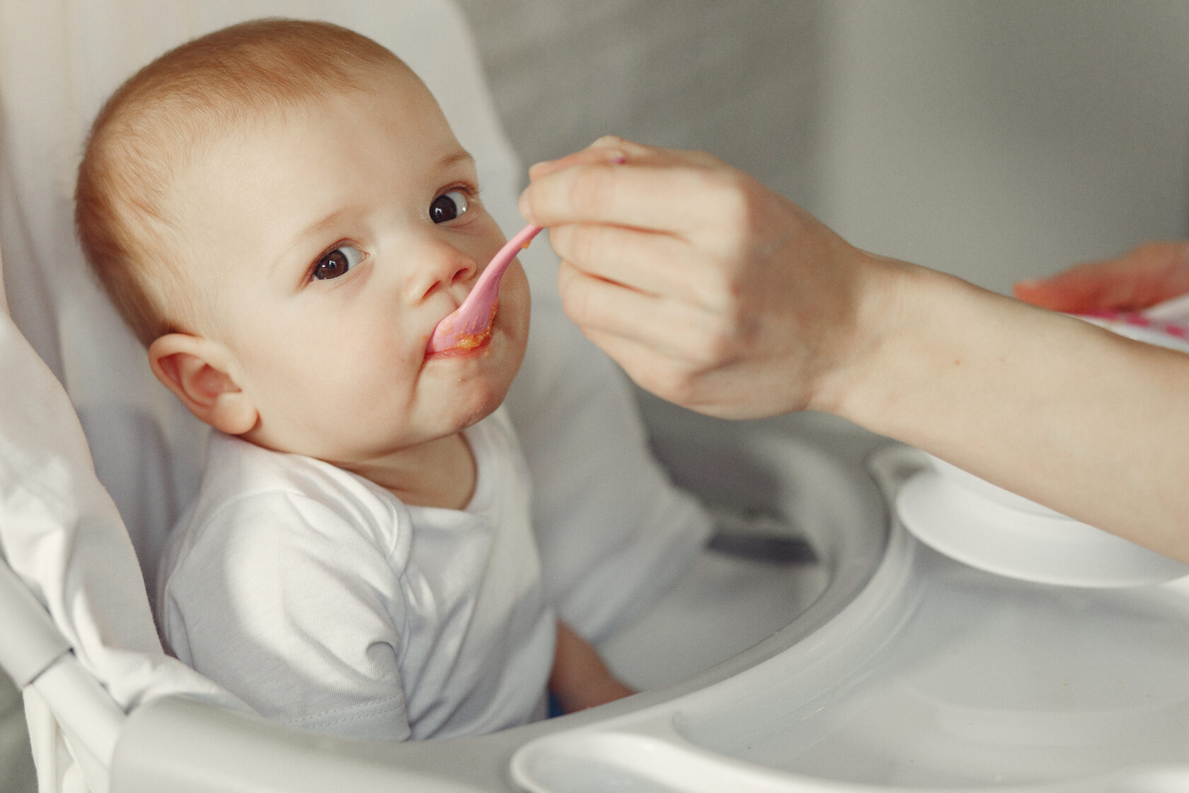 Baby showing signs of readiness for solid foods after recognizing early hunger cues and healthy milk intake.