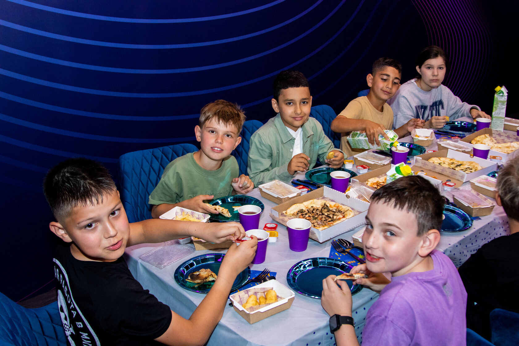 Детский день рождения Москва в Baza VR: дети за праздничным столом в банкетной зоне после игры.