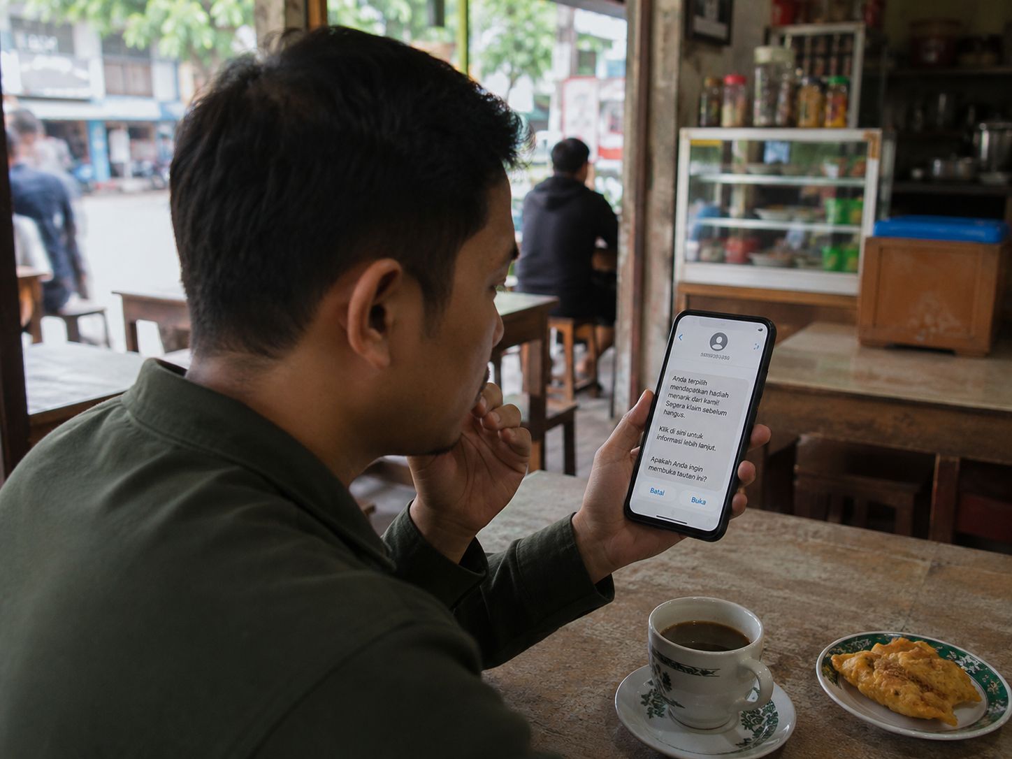 Pengguna ponsel berhenti untuk memeriksa pesan mencurigakan sebelum membuka tautan yang dikirim