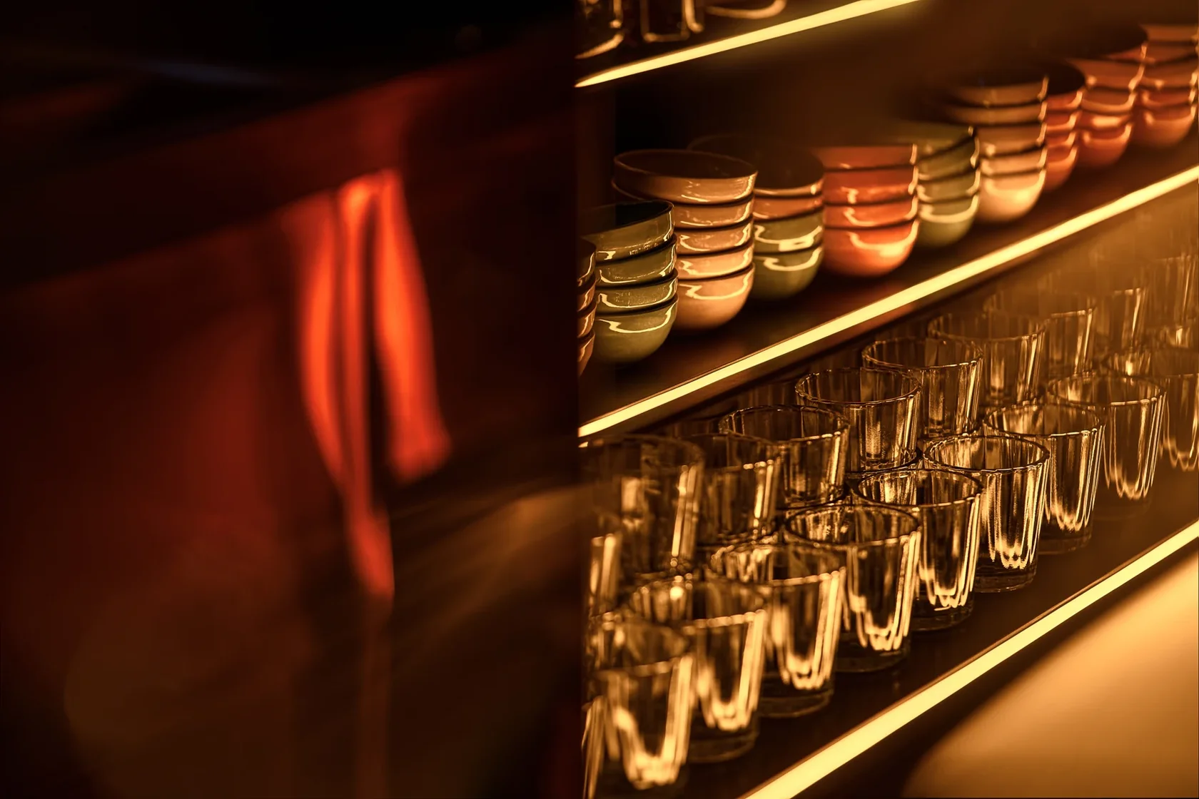 Warm backlit shelves, glasses and ceramics at the Sobremesa bar