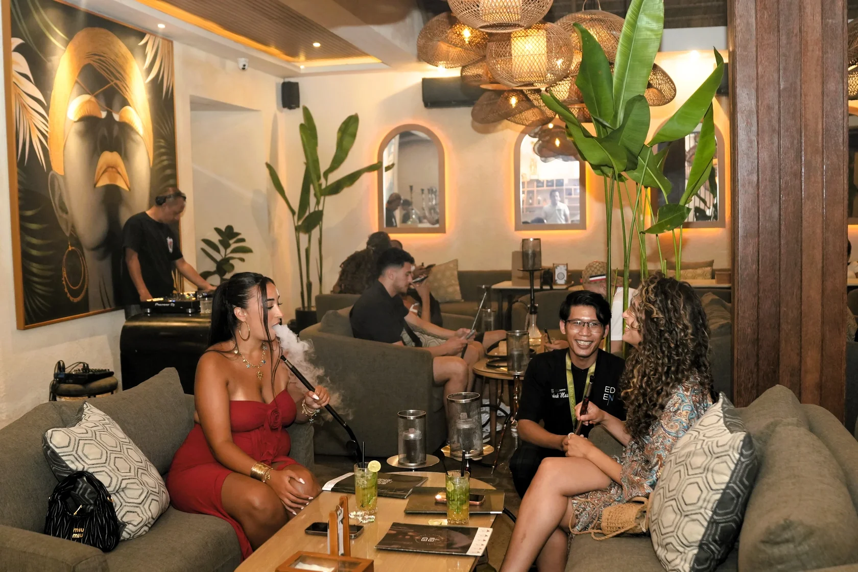 Friends laughing and enjoying a cozy evening with friendly staff and good shisha at Eden Hookah Club.