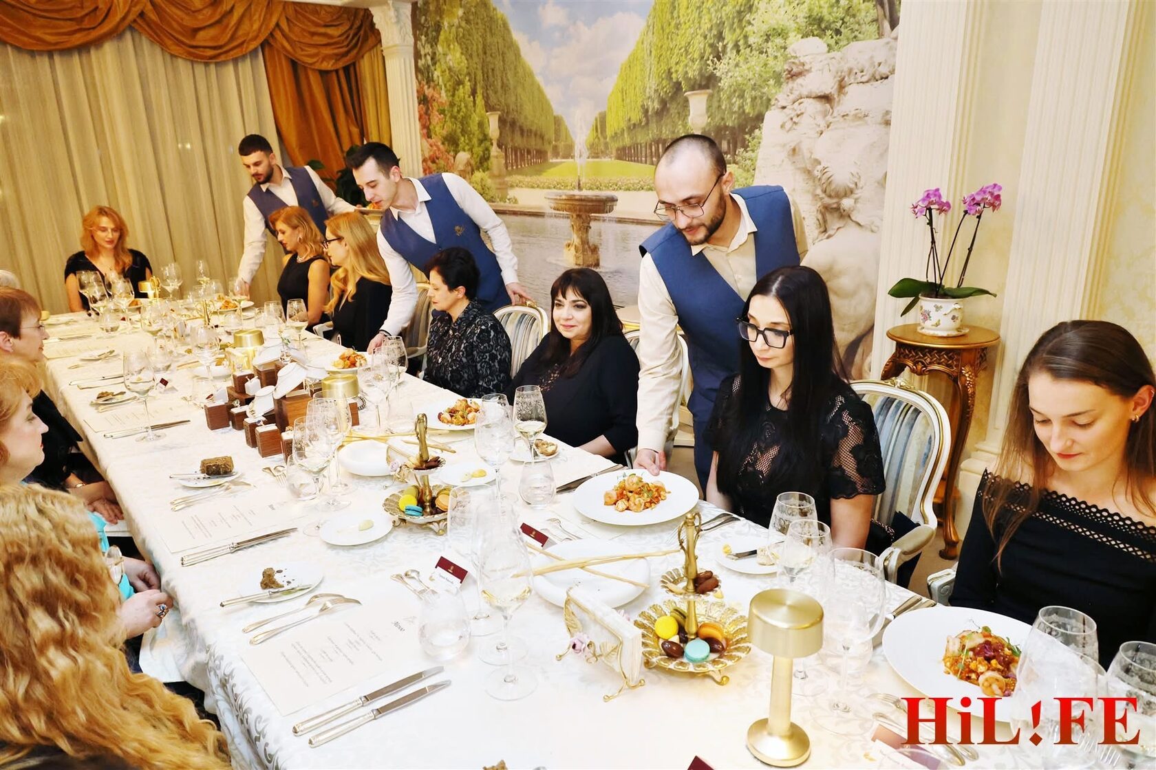 сервитьори поднасят гурме ястия в изискана обстановка в ESTE  Restaurant по време на събитие на Великолепната Жена