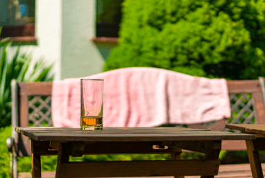 На столе стоит стакан с соком на улице