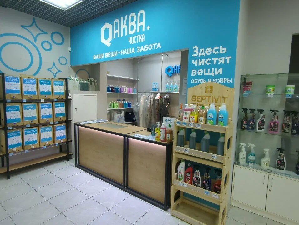 Стойка приёма под вывеской «Аква.Чистка. Ваши вещи — наша забота»