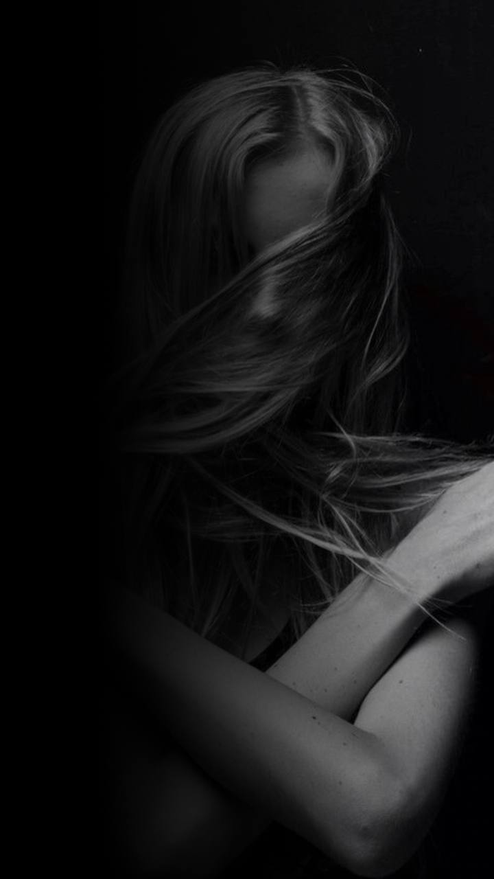 девушка с длинными волосами скрестила руки на плечах