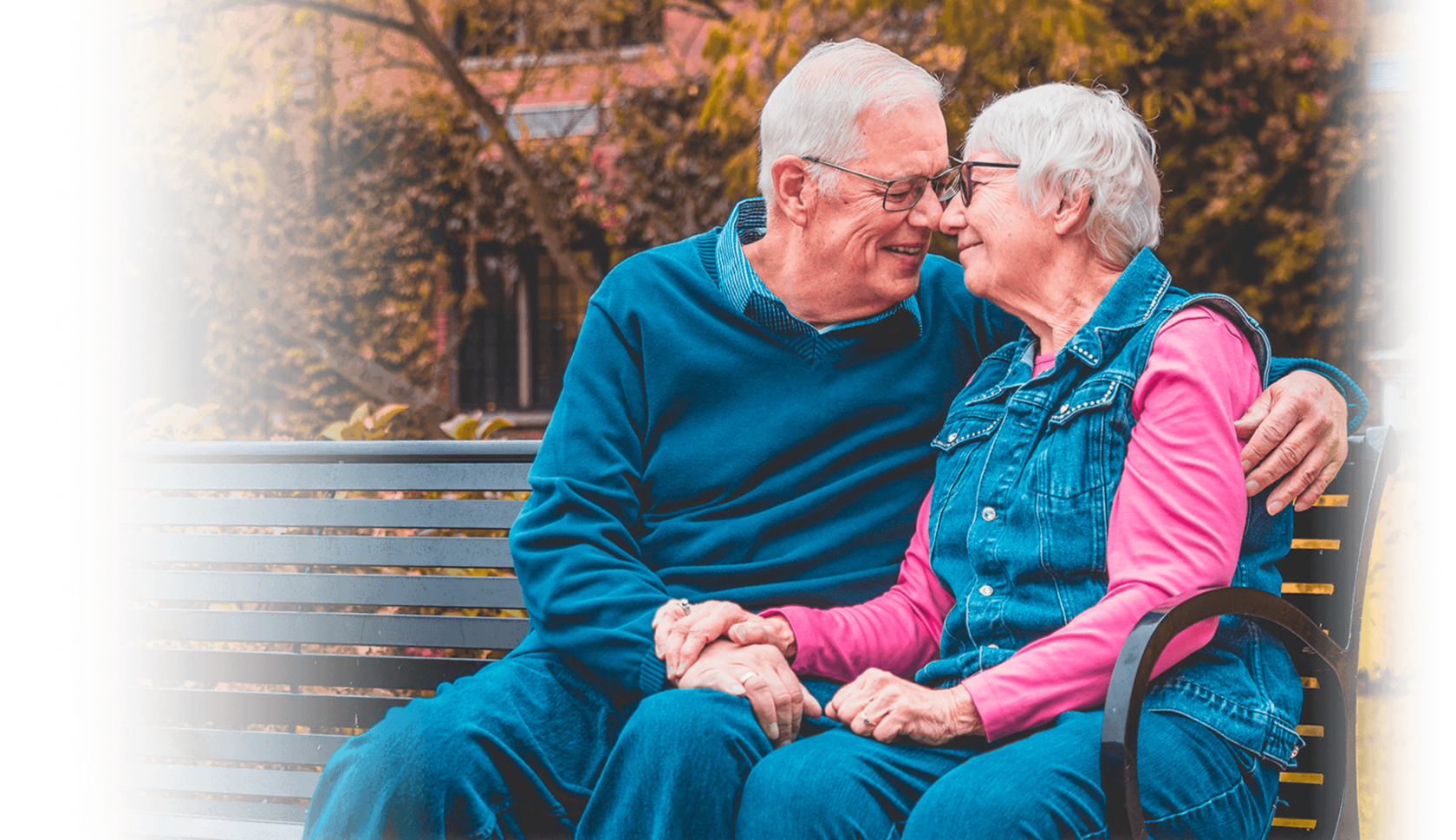 пожилая пара сидят на скамейке в обнимку счастливые и здоровые