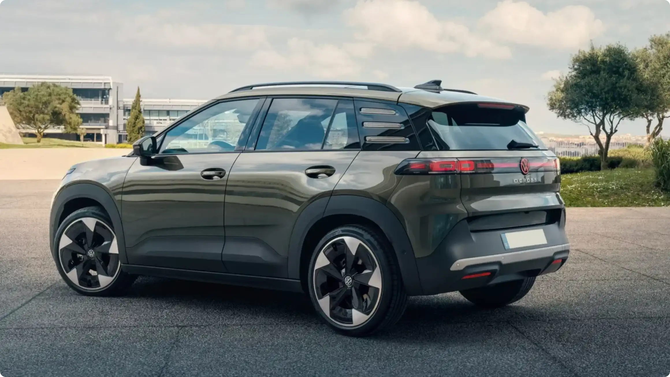Volkswagen ID. Cross в оливково-зеленом цвете, вид сзади сбоку: светодиодная полоса, черные пластиковые молдинги, рельефные вставки на стойках и двухцветные диски.