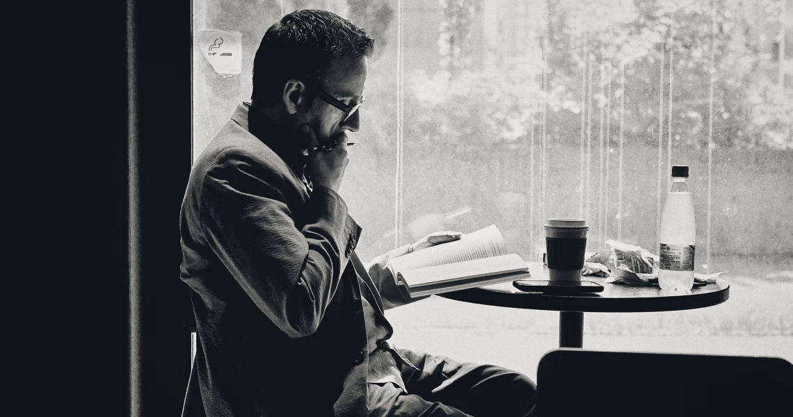 мужчина читает в кафе