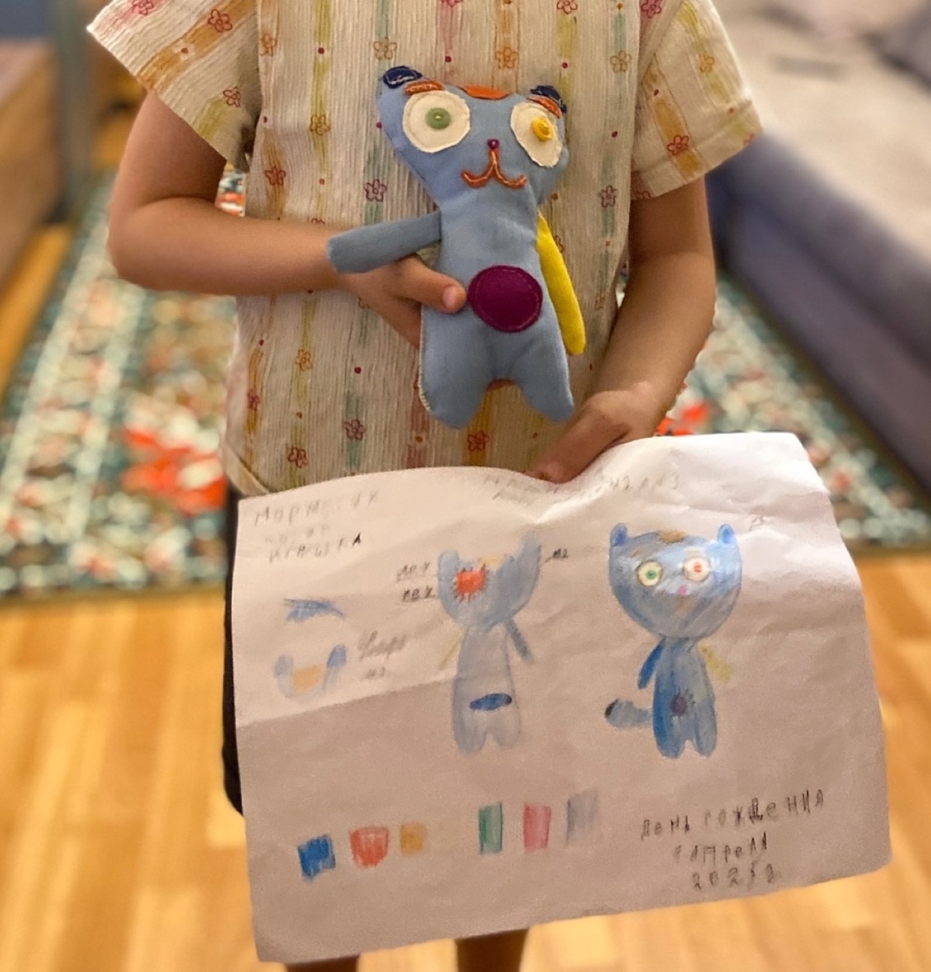 A child with their handmade Mormitten and drawing