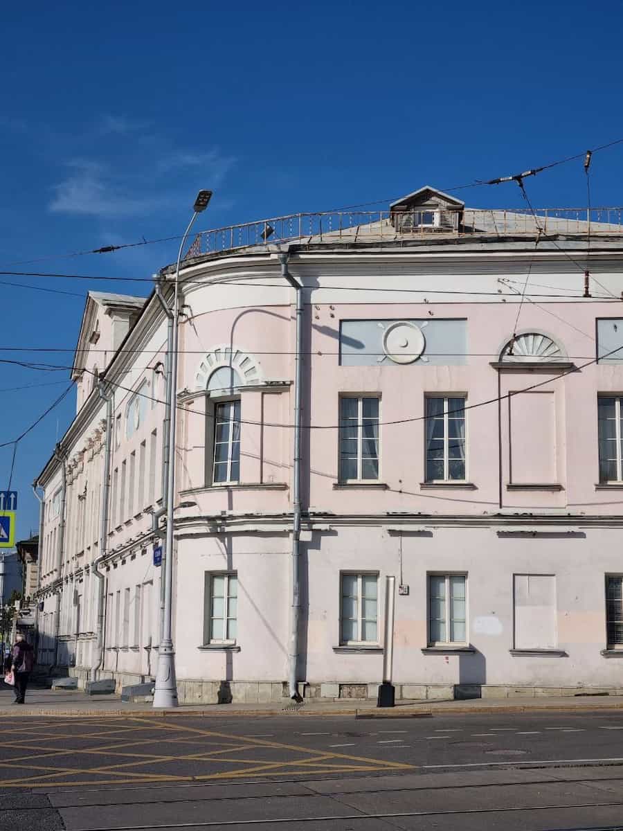 Угловой светло-розовый дом на городской улице у Хитровки