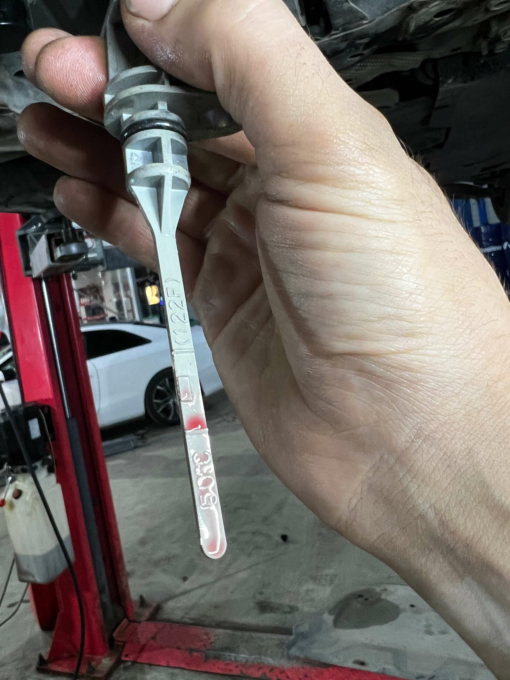 Уровень проверяется по щупу на запущенном двигателе