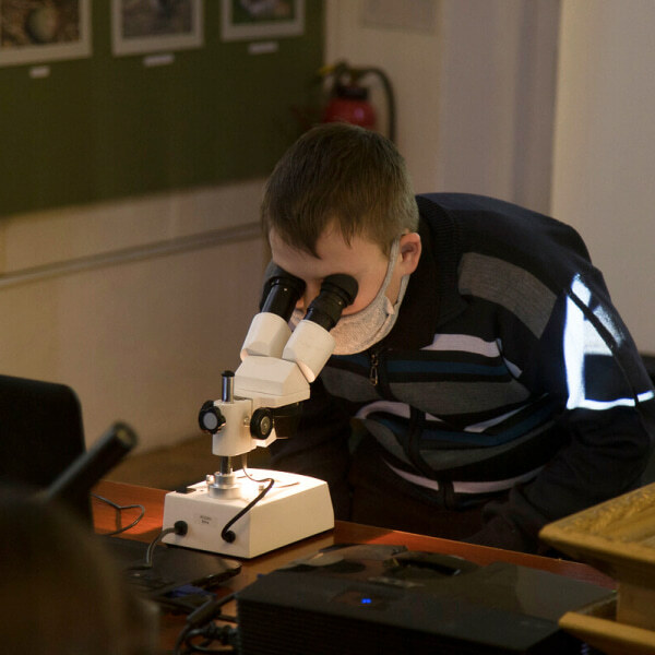 Ребенок на занятии с микроскопом