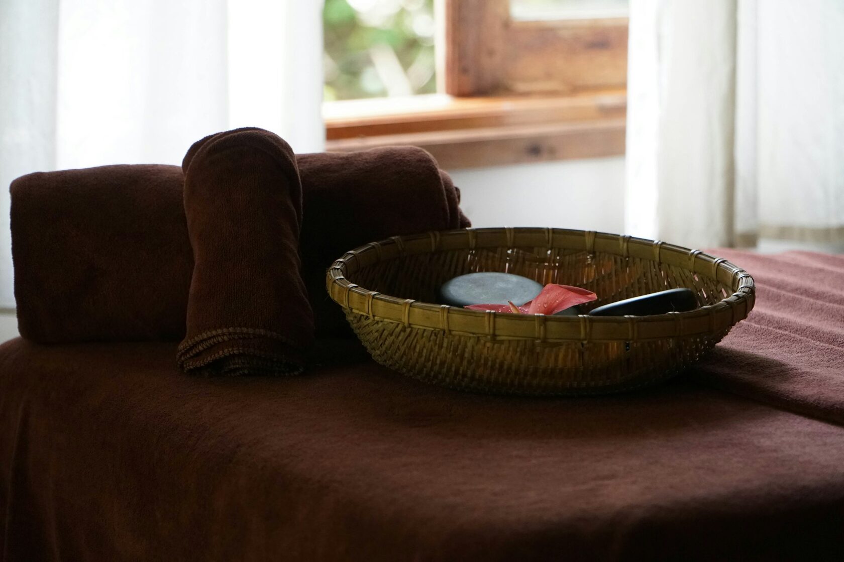 Ayurvedic herbal oils resting in a warm ceramic bowl before treatment