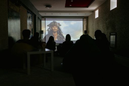 Домашний кинозал: большой экран, мягкий диван и приглушённый свет