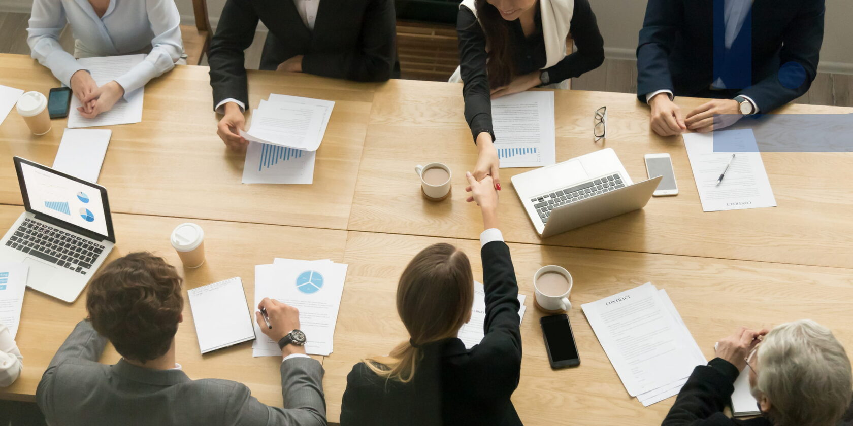 Team meeting at a worktable discussing tasks, results, and collaboration as part of effective one-on-one meetings and HR processes.