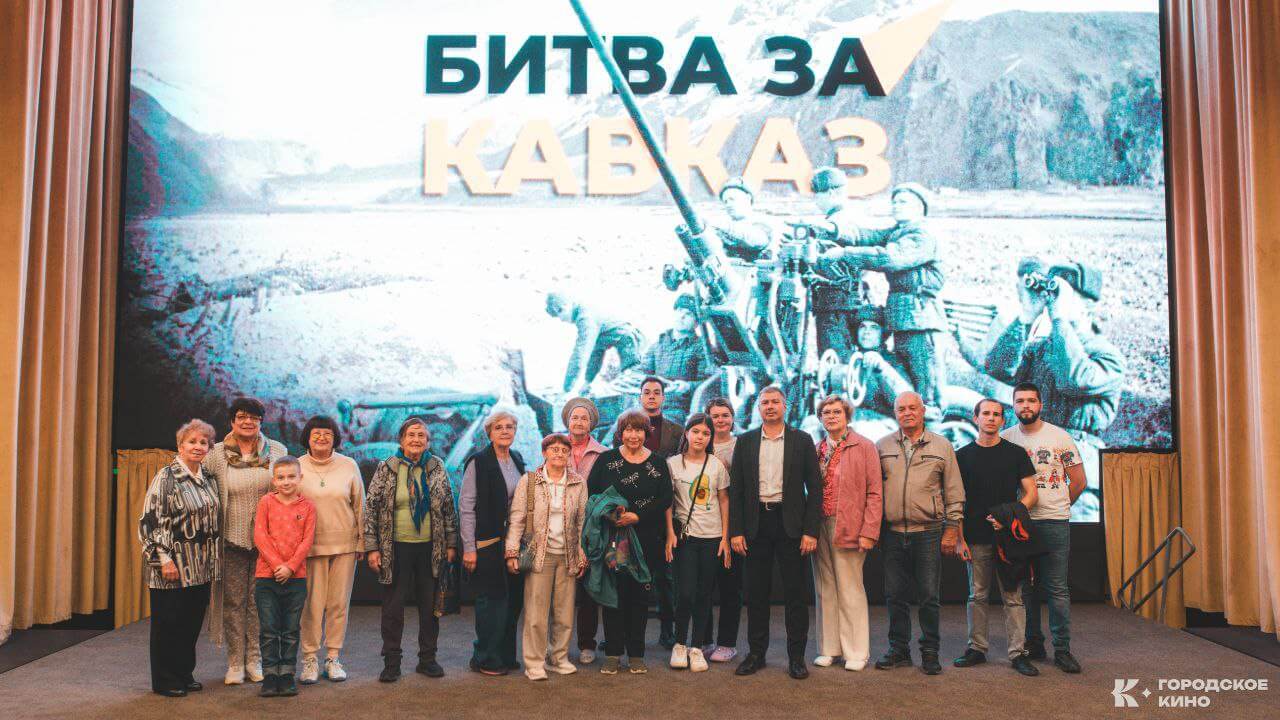 Участники кинопоказа «Потомки Победителей» в кинотеатре «Городское Кино» на фоне экрана с титром «Битва за Кавказ». Мероприятие в честь 80-летия Победы в Великой Отечественной войне.