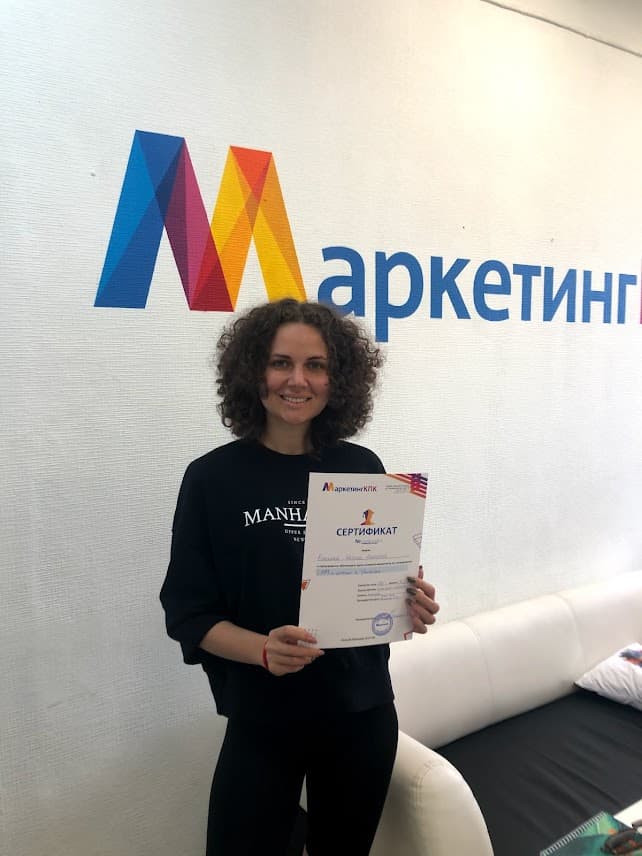 Выпускница держит сертификат о повышении квалификации