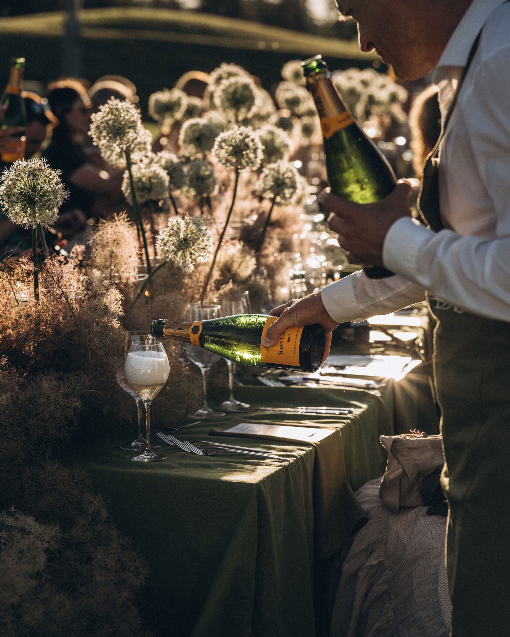 Сервитьор налива пенливо вино на събитието The Golf Dinner by Food Nomads 