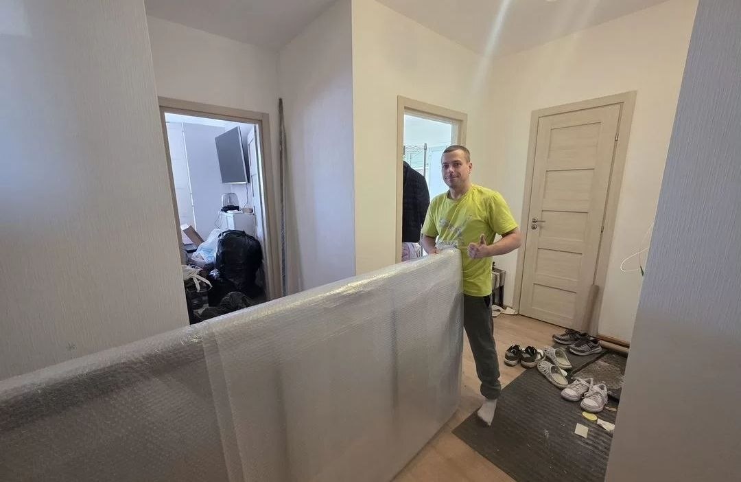 Грузчик выносит матрас из квартиры