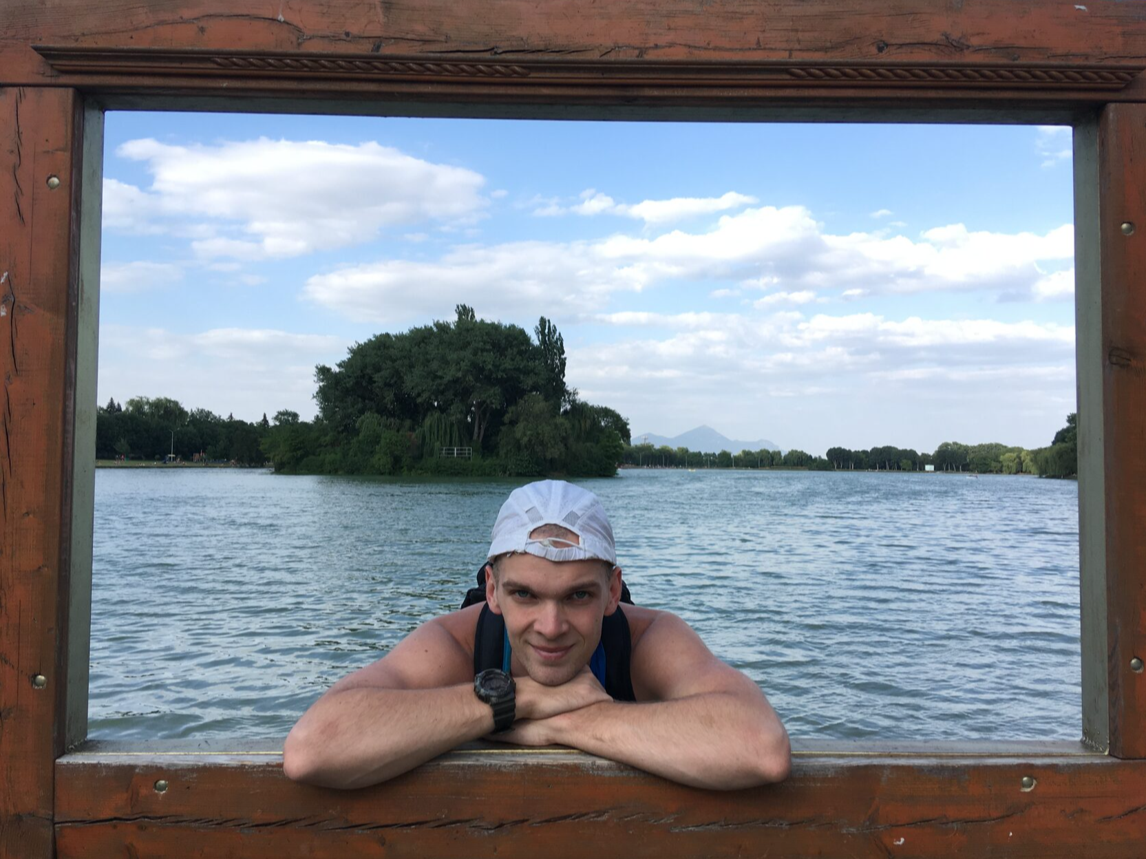 Тренер, который смотрит за учениками на фоне яркого пейзажа в обрамлении прямоугольной деревянной рамки