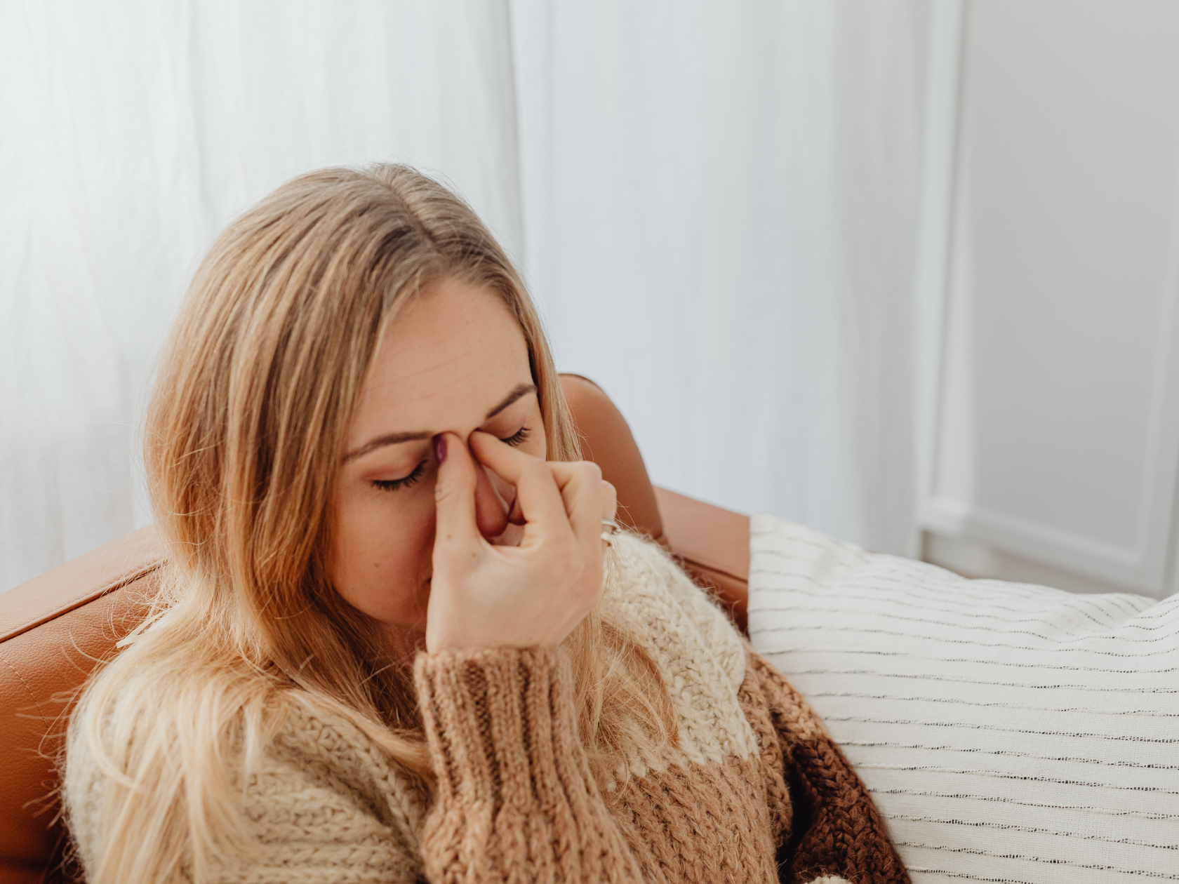 Женщина испытывает боль в голове от стресса и бруксизма