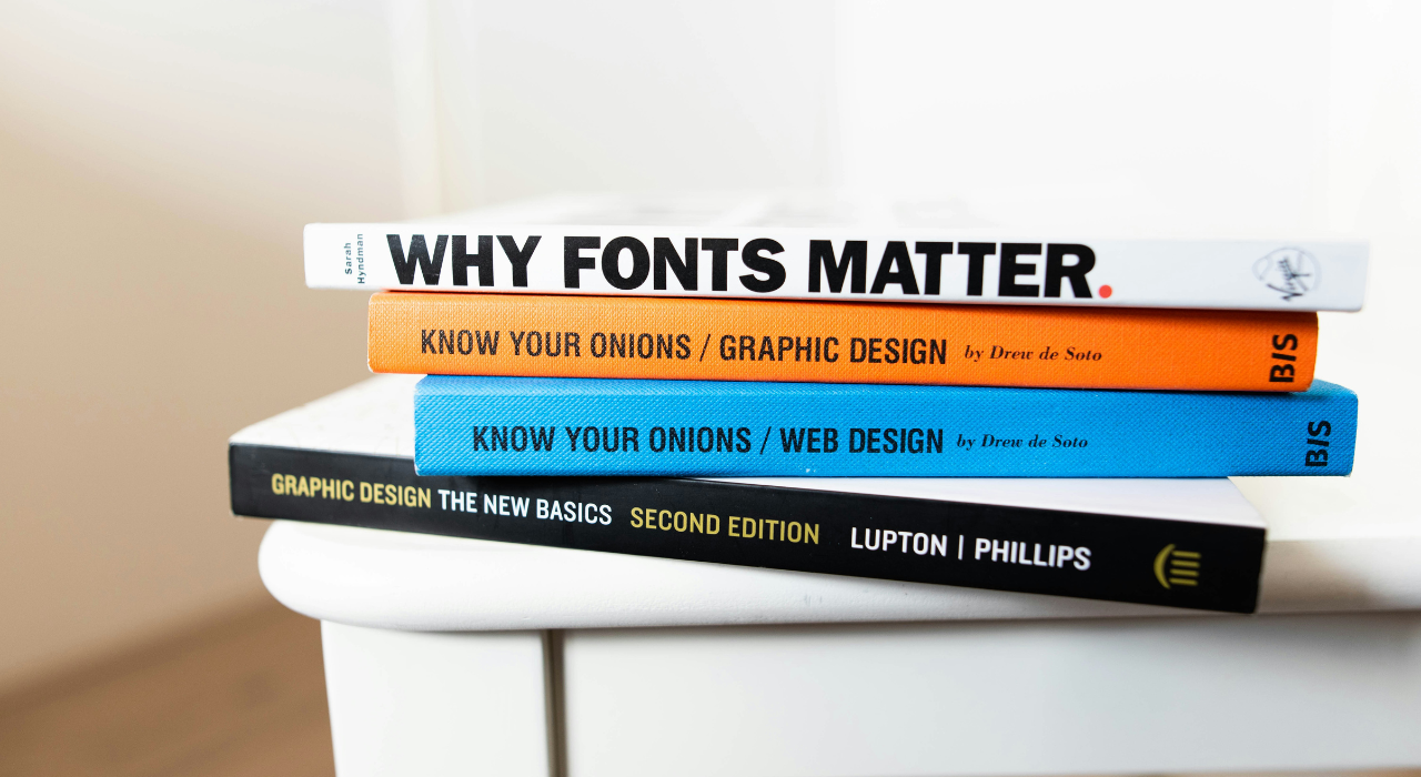 Stack of typography and graphic design books related to fonts and visual communication.