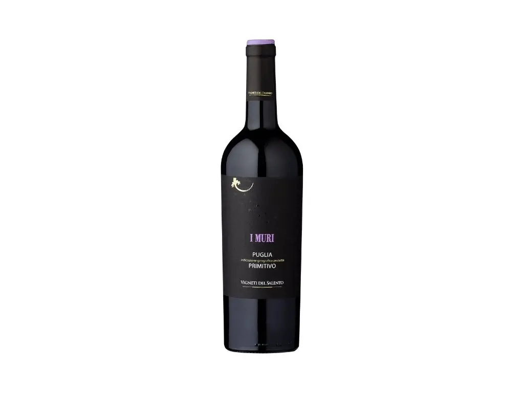 A rich glass of I Muri Primitivo, a great imported wine in Bali, resting on a lounge table.