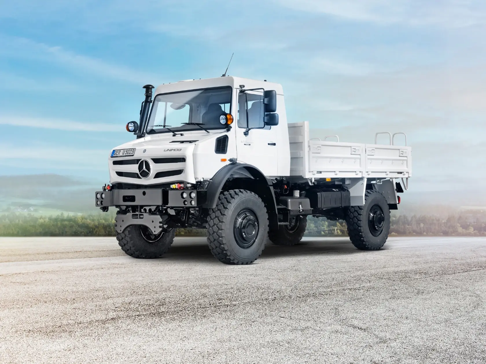 Белый Unimog на загородной дороге