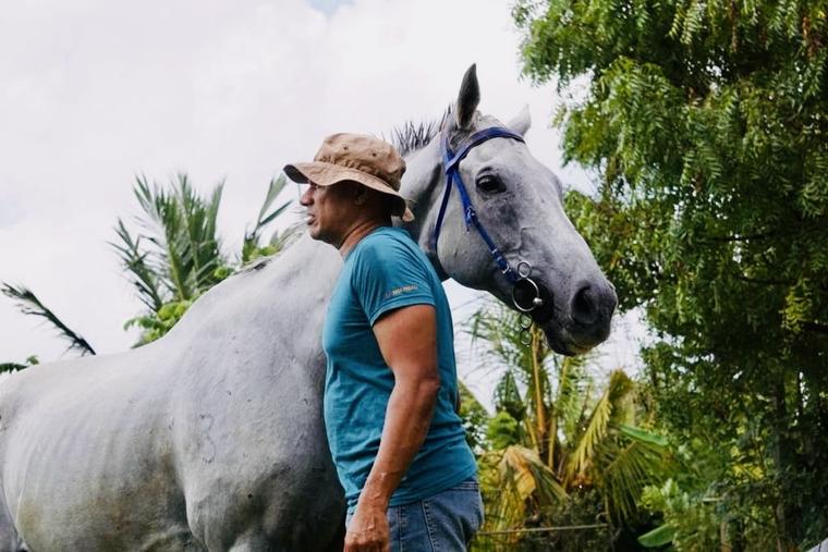Ethical horseback rider beside a calm grey horse in tropical Sri Lankan terrain at Vonfidel Ranch, reflecting trust-based horsemanship, rider restraint, horse welfare, low-volume trail riding, and the philosophy that true riding begins with systems, respo