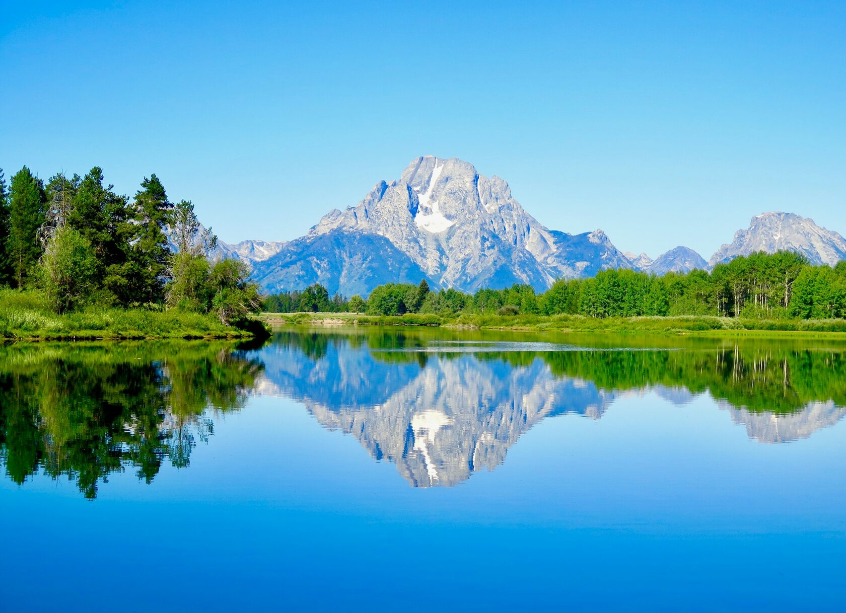 Still lake reflecting distant mountains