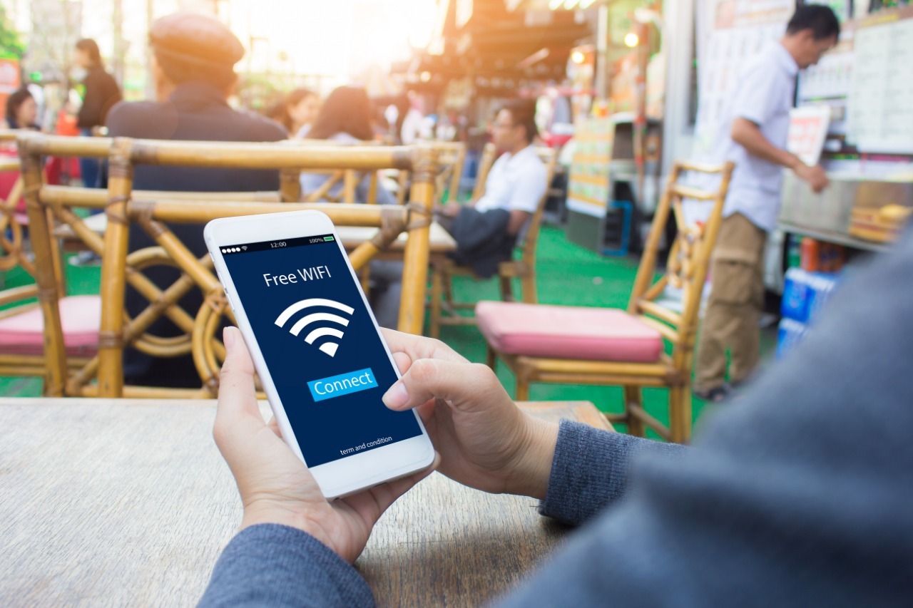 Человек подключается к бесплатной сети Wi-Fi через смартфон в общественном месте.