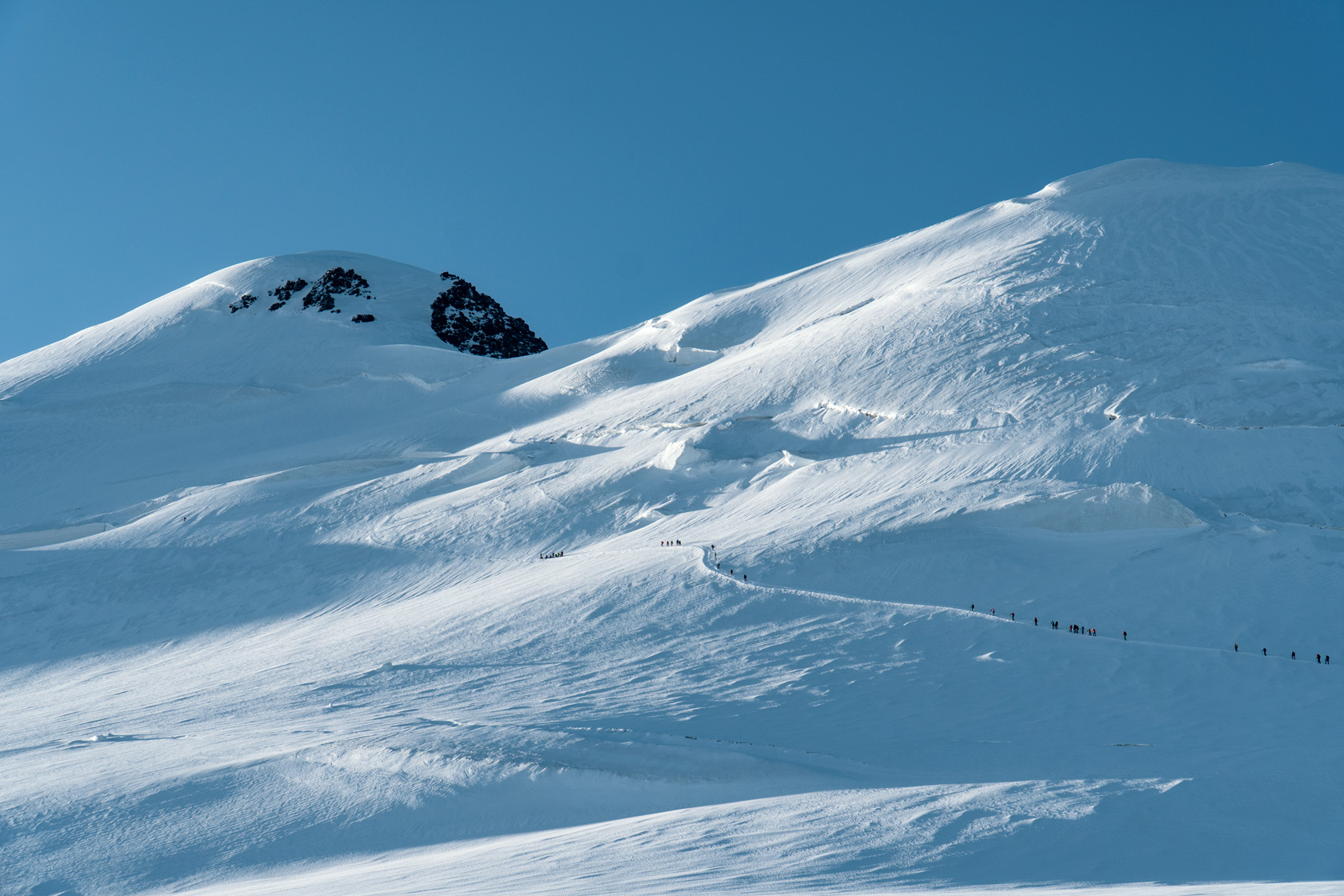 Гора Казбек. Тропа к вершине горы Казбек по которой идут альпинисты. Северный склон горы Казбек. Фотограф Севальнев Ян.