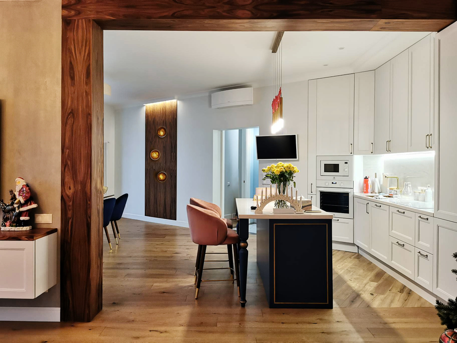 белый кухонный гарнитур, синий кухонный остров, деревянная балка, деревянный пол, подвесные светильники
