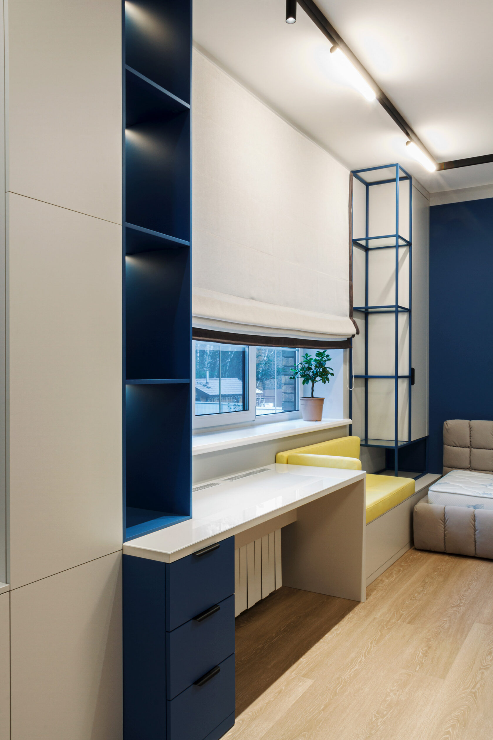 Рабочая зона в детской: стол с подсветкой, стеллажи и встроенные ящики для хранения — всё продумано под рост ребёнка и школьные нужды.