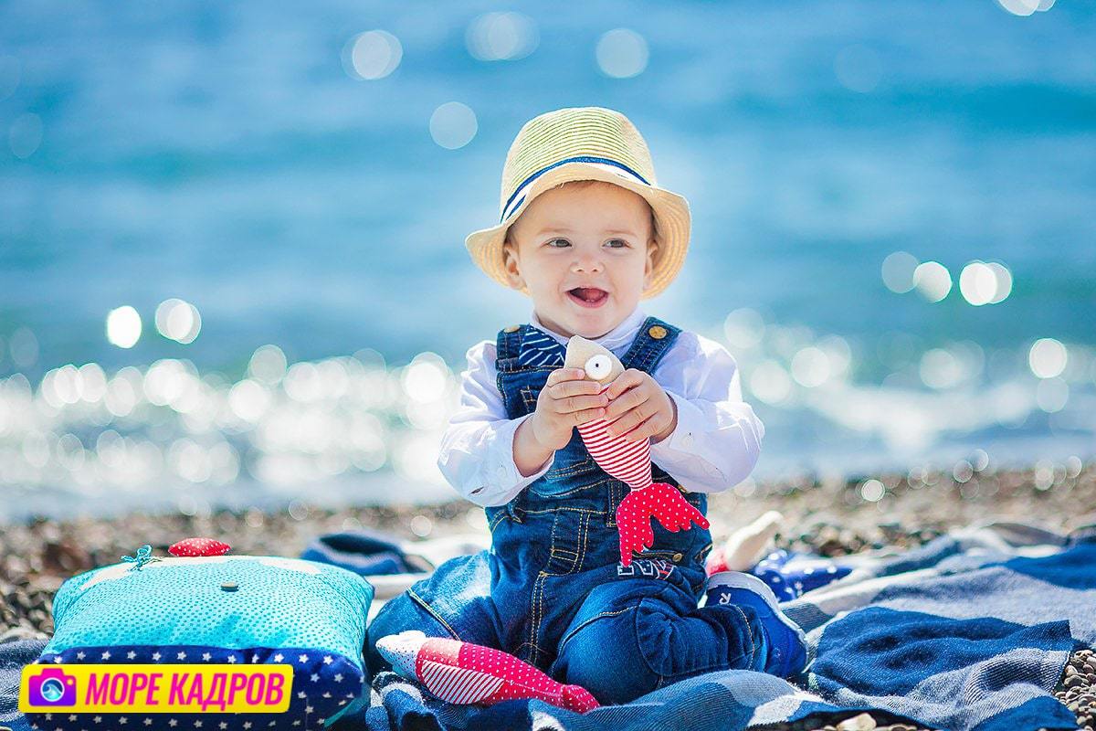 ребенок на берегу моря играет с рыбками, Крым, Судак