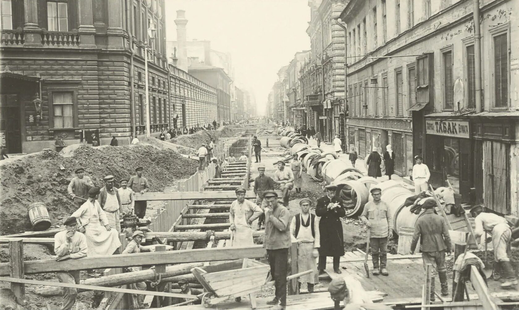 фотография строительства первого водопровода Петербурга, где изображена оживленная улица с рабочими и прохожими