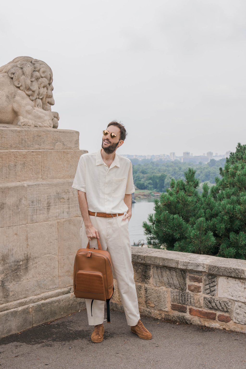 Shirt: Loro Piana  Backpack: BIAGINI  Trousers: Loro Piana  Belt: BIAGINI  Sunglasses: Linda Farrow  Sneakers: Loro Piana