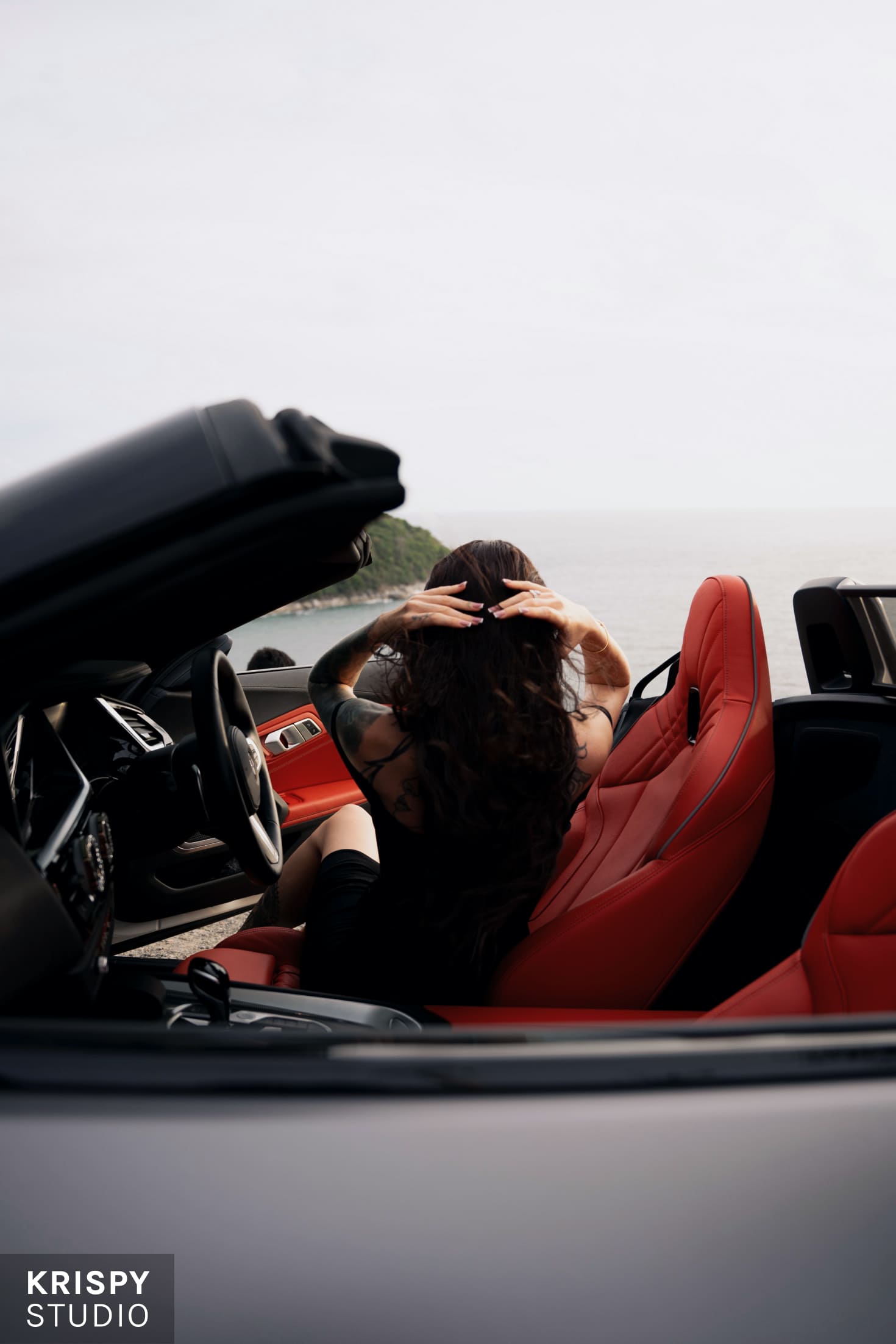 Сексуальная женщина в кабриолете с красным салоном, имиджевая съемка бренда одежды
