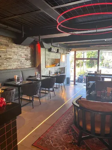 The practical, industrial-style seating area under a glowing red neon ceiling ring at CUBE PC Club and Cafe, a versatile spot in the best shisha lounge in Bali ecosystem.