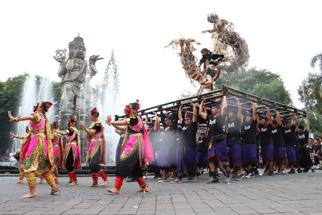 A spirited group of Balinese locals carrying a handcrafted Ogoh-Ogoh statue and dancing during the vibrant parade on the eve of Nyepi.
