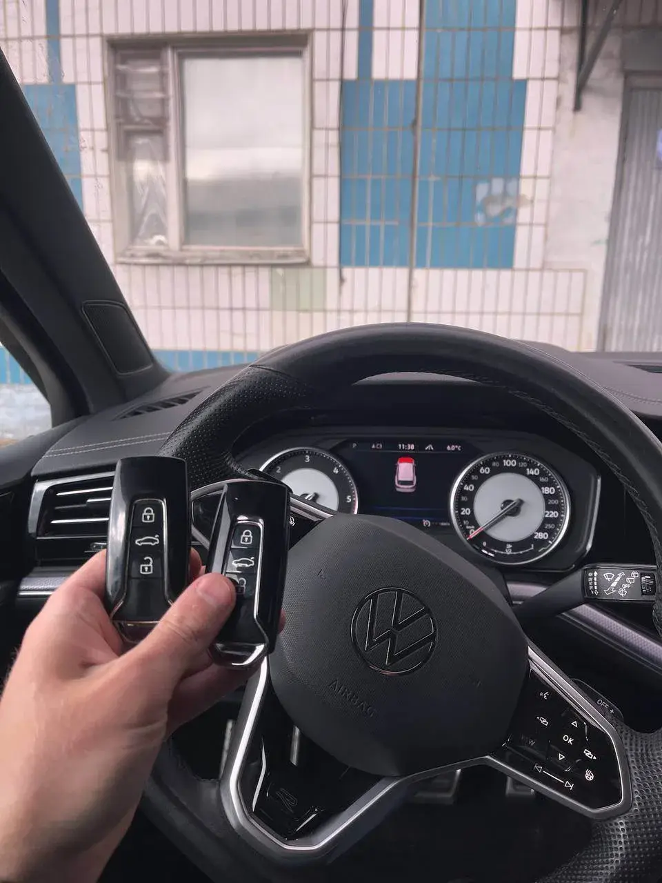 Два ключа Volkswagen на фоне руля