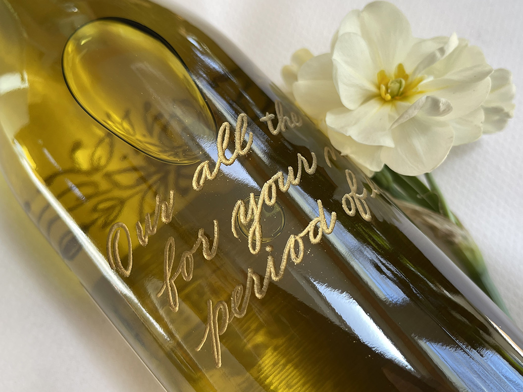 Close up of hand engraved wine bottle with gold fill