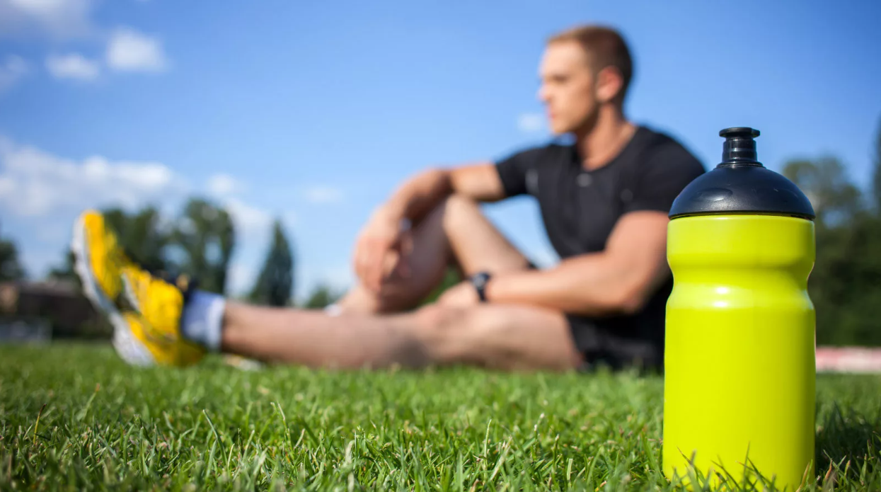 Отдых и восстановление спортсмена. Спортсмен с бутылкой воды. Бутылка для спортсменов. Спортивная бутылка на траве. Пробежки с бутылкой воды.