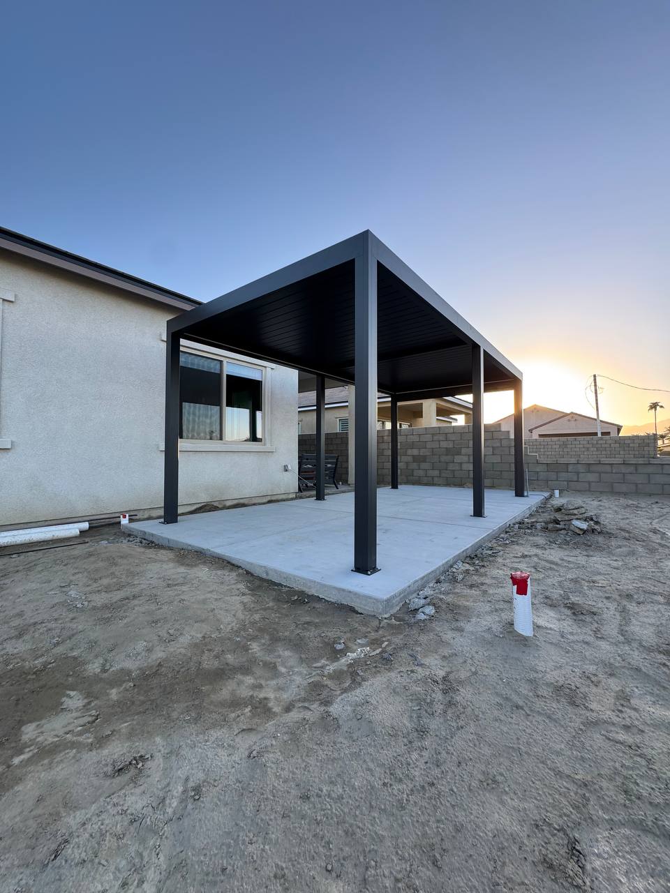 Completed dark gray 10 by 19 freestanding pergola on a concrete patio in Yorba Linda