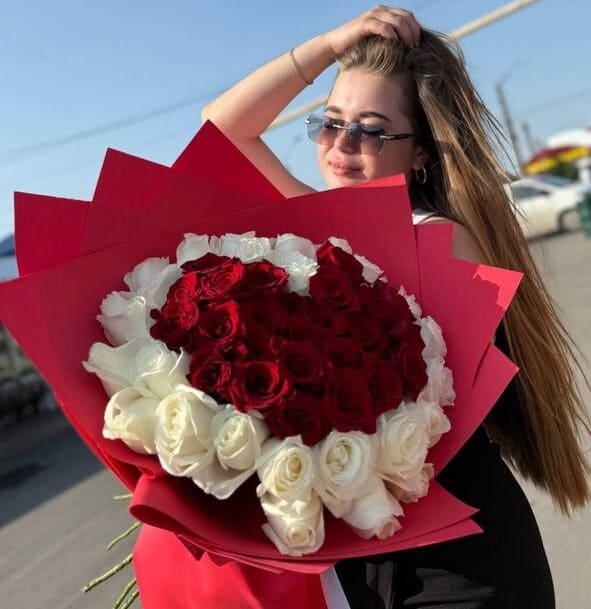 Девушка держит в руках букет из 51 розы в форме сердца