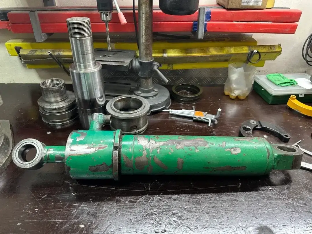 Разобранный гидроцилиндр на рабочем месте в процессе ремонта