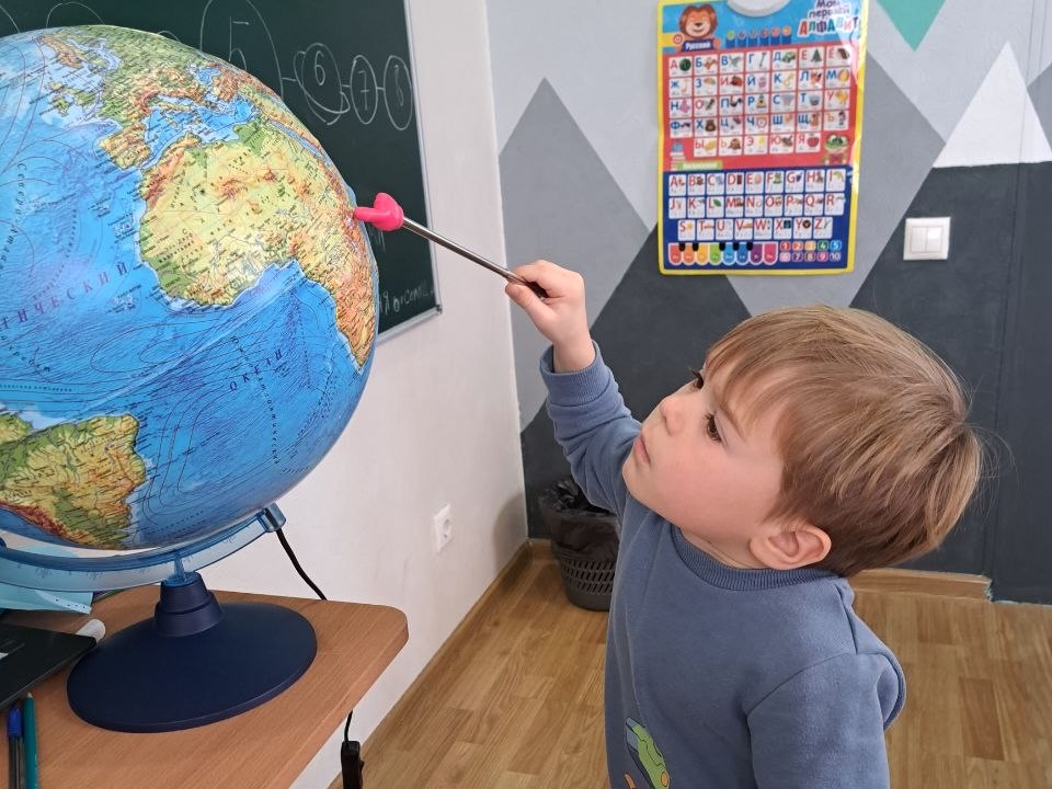Педагог прескула РайСкай занимается с детьми в классе с видом на море в Сочи