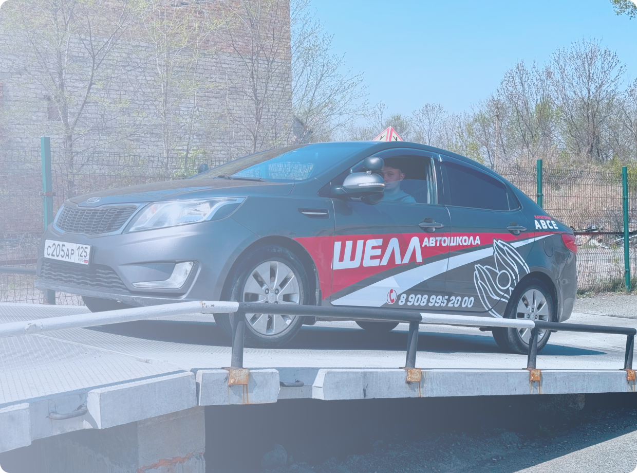 Черно-бронзовый мотоцикл стоит на стоянке у серого бетонного здания, вид сбоку