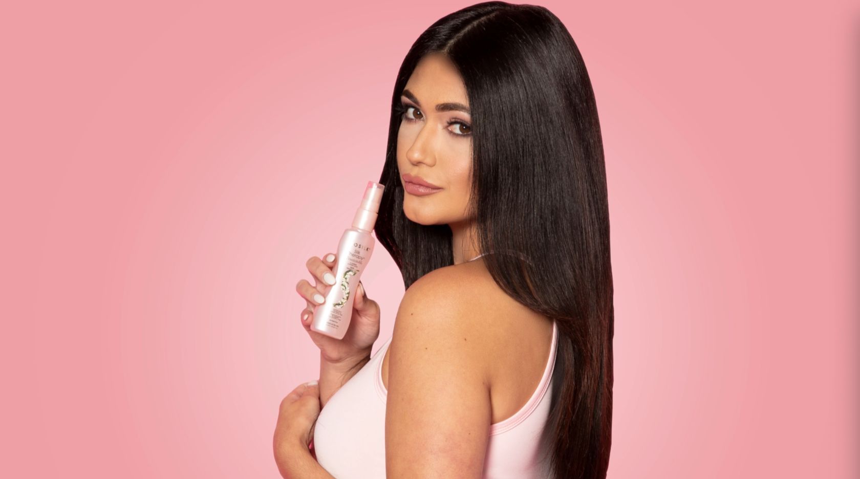 Девушка с темными волосами держит в руках шампунь Biosilk